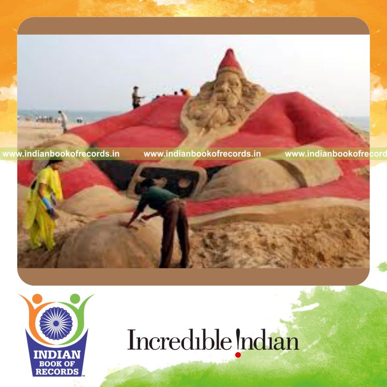 team creating large sand sculpture of santa claus for record in Indian Book of Records