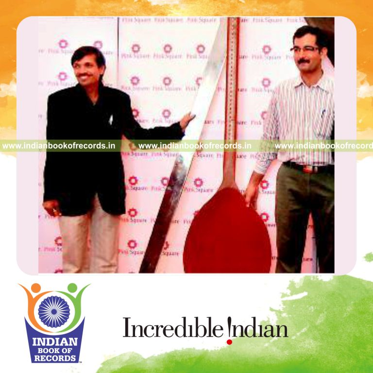 male individual creating a large wooden spoon for record in Indian Book of Records