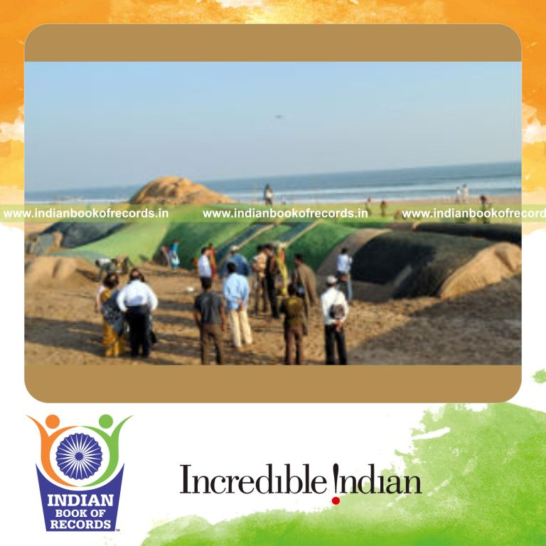 male individual creating long green santa sculpture for record in Indian Book of Records