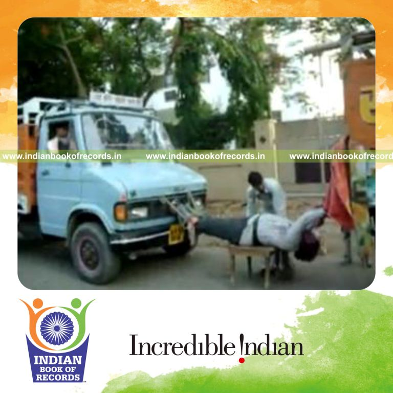 individual suspended in mid air between moving trucks for record in Indian Book of Records